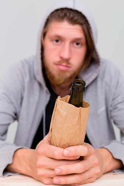 грустный парень держит в руках бутылку пива
