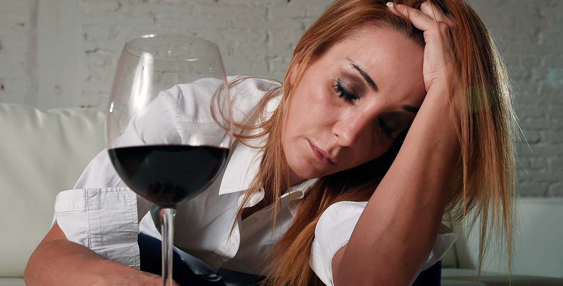 грустная женщина рядом с бокалом вина